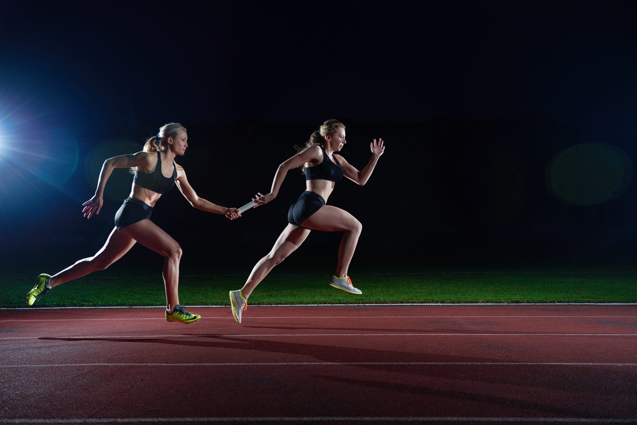 Athletic Runners Passing Baton In Relay Race Axialent